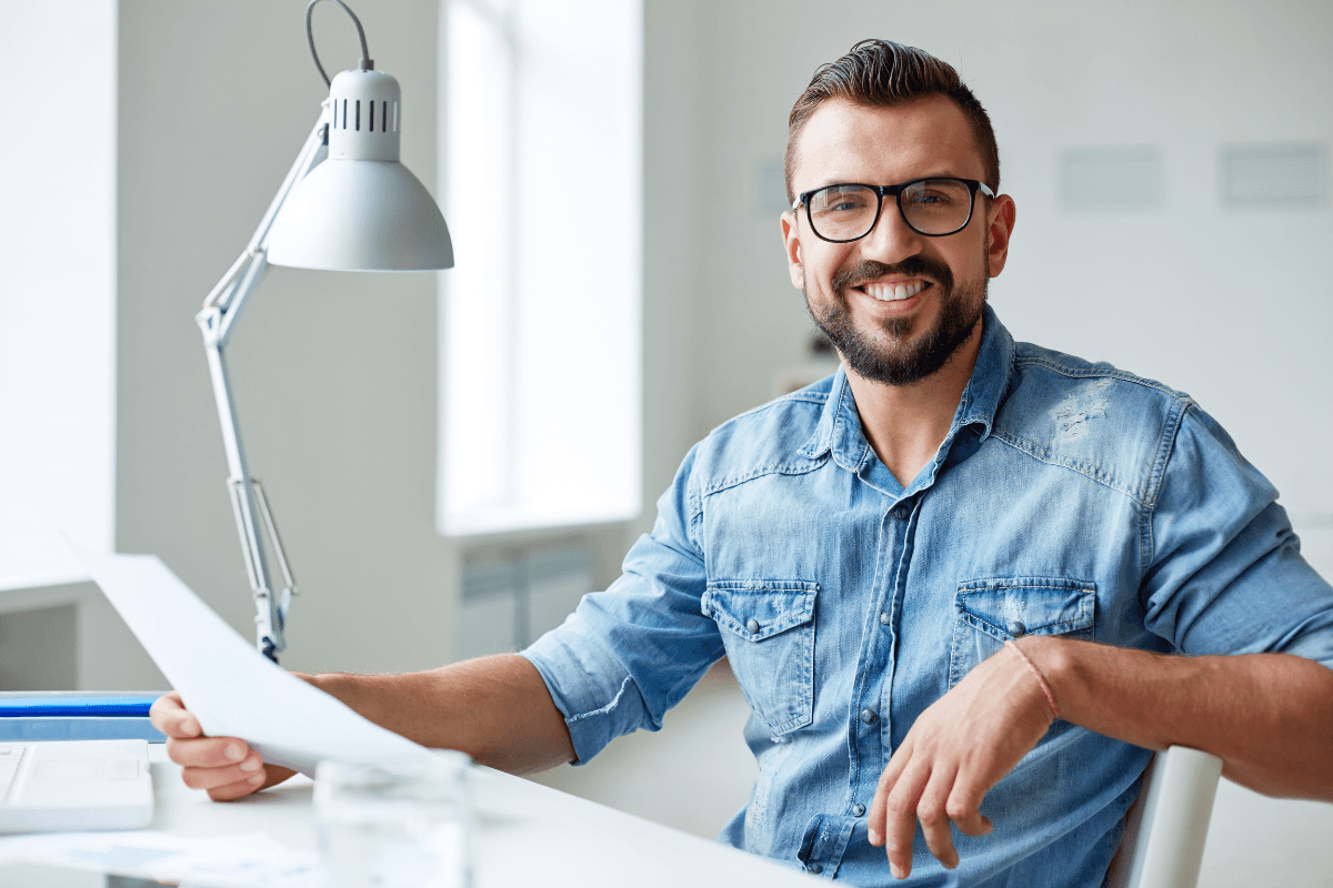 Man houd papier vast en zit aan bureau